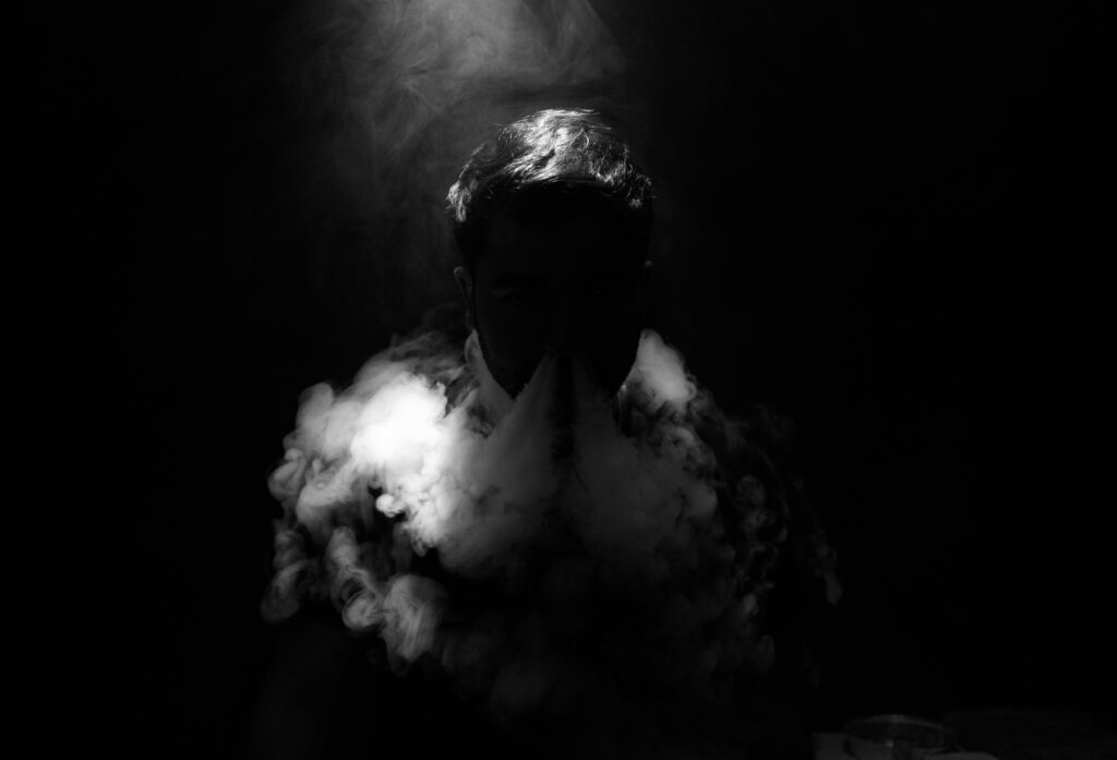 An individual exhaling vapour via the use of a vape